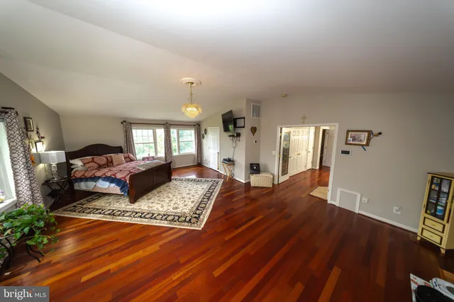 a bedroom with a bed and a flat tv screen on dresser