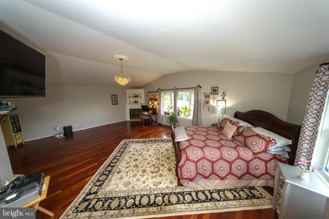 a view of hallway with window and wooden floor
