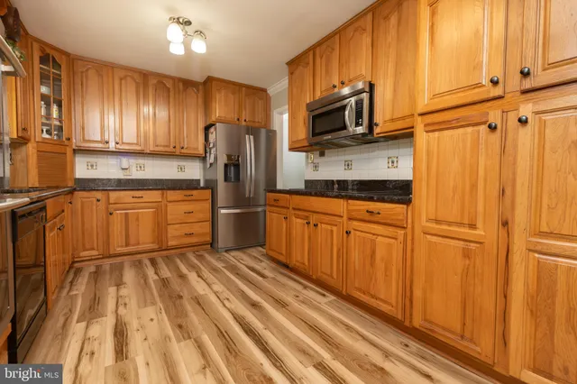 a kitchen with granite countertop wooden cabinets and a stove top oven
