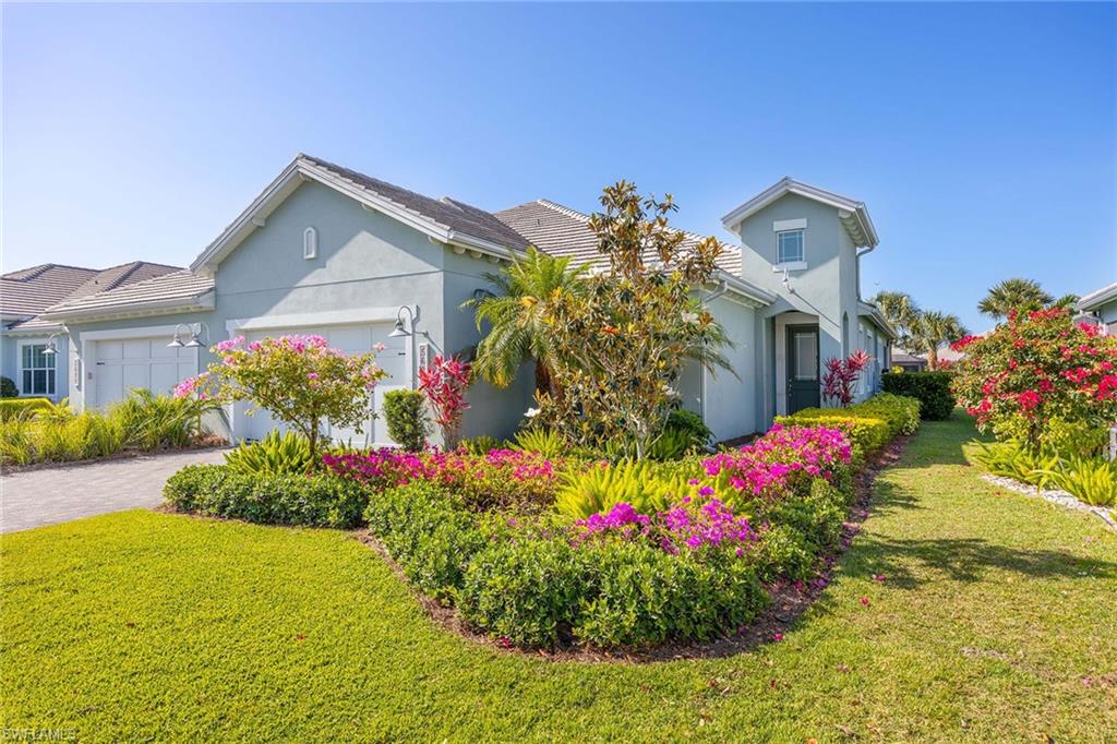 5626 Elbow Avenue Naples, FL 34113 - Photo 1 of 48 a front view of a house with a yard and fountain