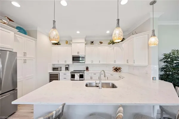 a kitchen that has a lot of cabinets and stainless steel appliances