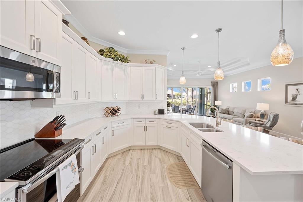5626 Elbow Avenue Naples, FL 34113 - Photo 14 of 48 a large white kitchen with a stove a sink a refrigerator and a microwave