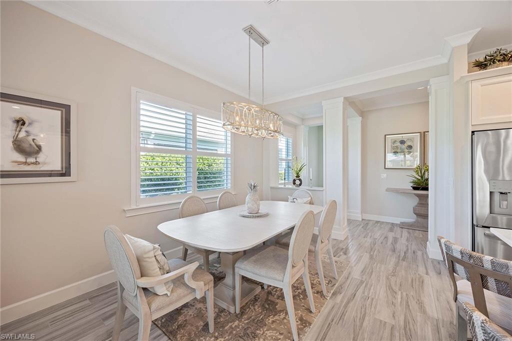 5626 Elbow Avenue Naples, FL 34113 - Photo 16 of 48 a view of a dining room with furniture window and wooden floor