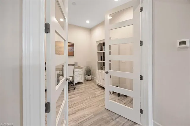 a hallway with white cabinets and wooden floor
