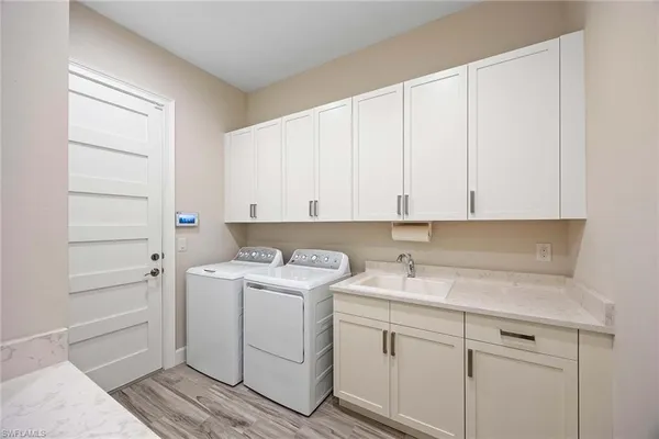 a view of a storage and utility room with closet dryer and washer