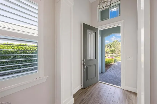 a view of a hallway with wooden floor and a dining room