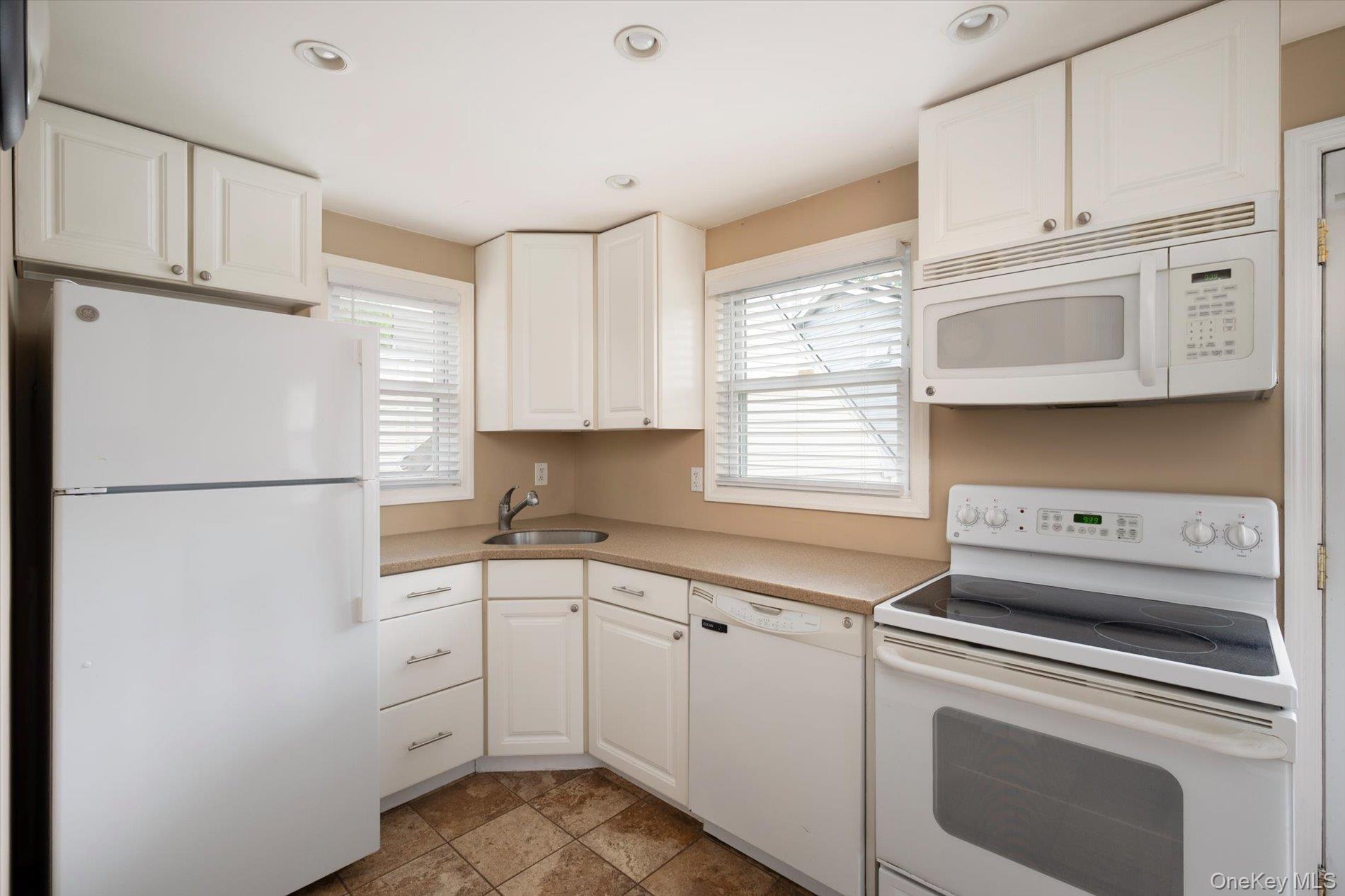675 Little E Neck Road West Babylon, NY 11704 - Photo 6 of 20 a kitchen with white cabinets and white appliances
