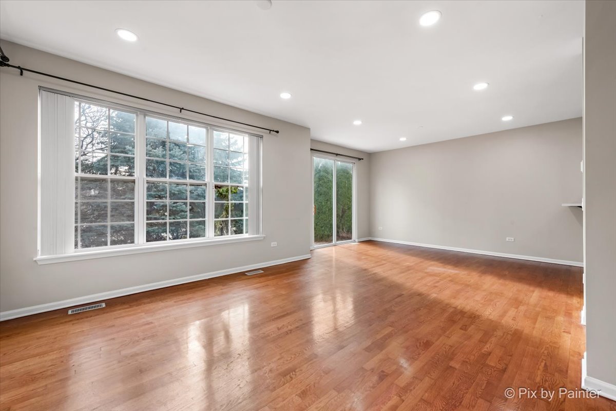 486 Vaughn Circle Aurora, IL 60502 - Photo 4 of 40 a view of an empty room with a window and wooden floor