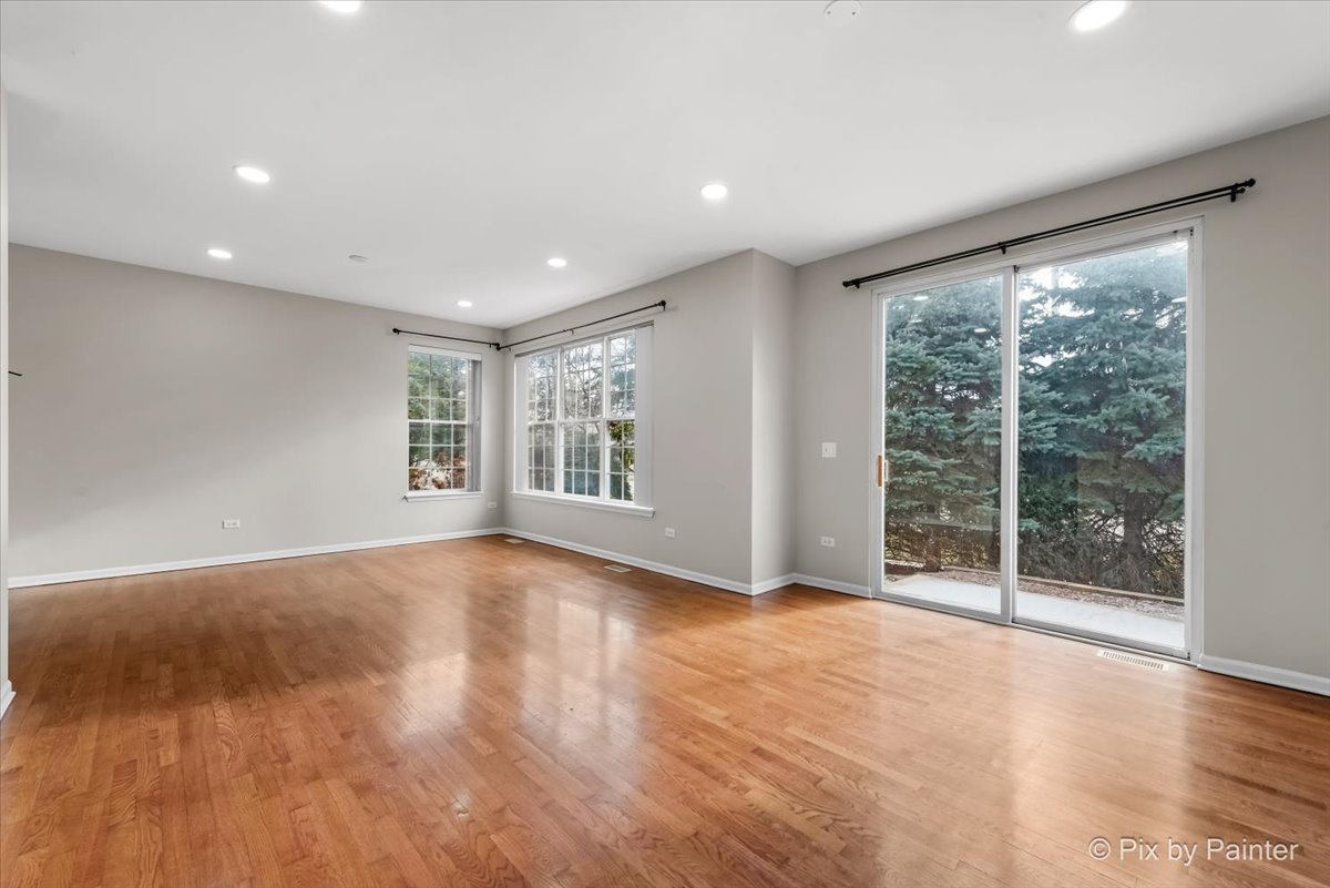 486 Vaughn Circle Aurora, IL 60502 - Photo 7 of 40 a view of an empty room with wooden floor and a window