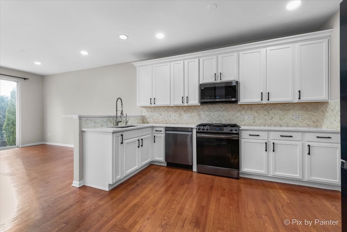486 Vaughn Circle Aurora, IL 60502 - Photo 9 of 40 a kitchen with wooden floors and appliances