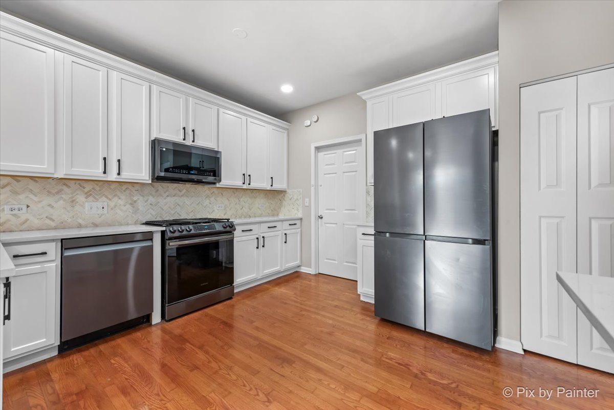 486 Vaughn Circle Aurora, IL 60502 - Photo 10 of 40 a kitchen with kitchen island a refrigerator sink and wooden floor