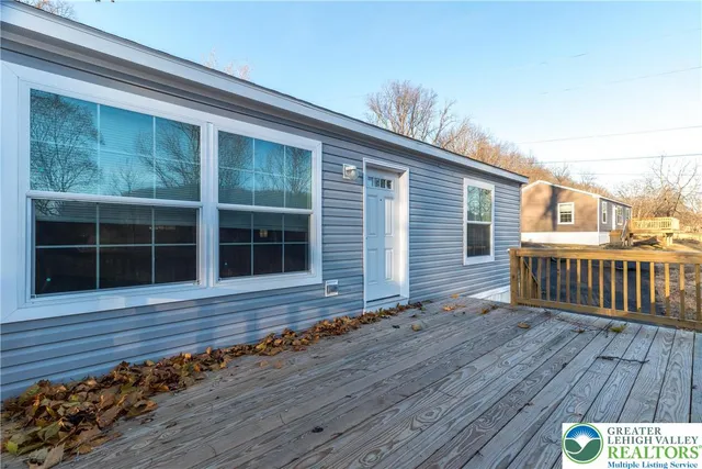 a view of house with deck and wooden floor