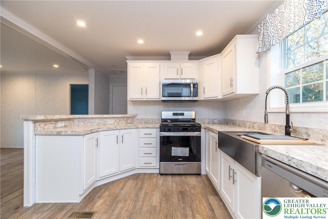 465 Royal Manor Road, Unit LOT 8 Easton, PA 18042 - Photo 3 of 23 a kitchen with stainless steel appliances granite countertop a sink stove microwave and refrigerator