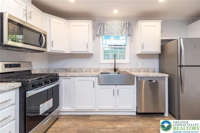 a kitchen with stainless steel appliances a stove microwave and refrigerator