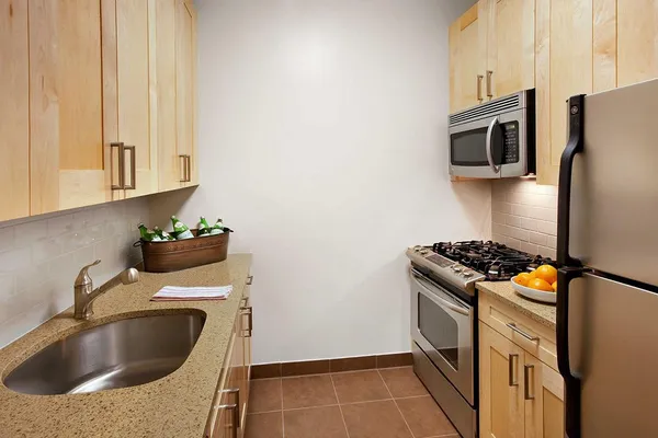 a kitchen with granite countertop a sink stove and refrigerator