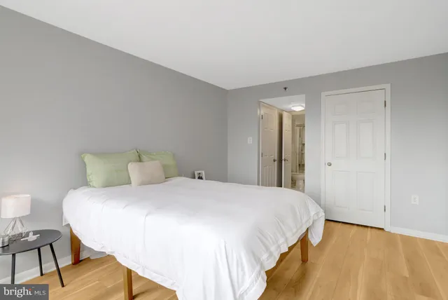 a bedroom with a bed and wooden floor