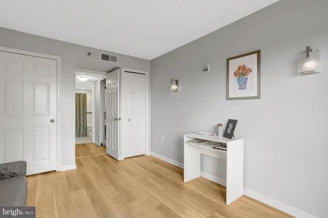 a view of a hallway with wooden floor and a living room