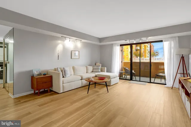 a living room with furniture a flat screen tv and a large window
