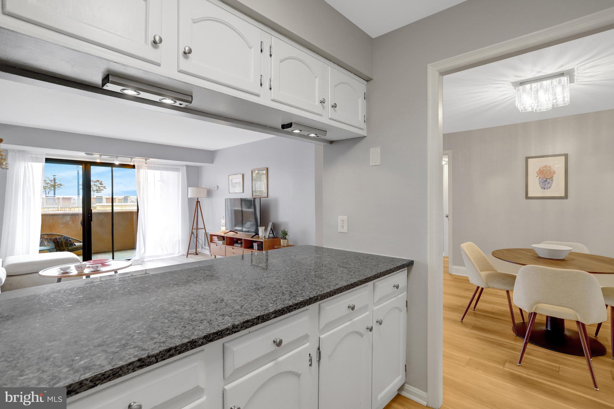 1301 North Courthouse Road, Unit 1108 Arlington, VA 22201 - Photo 8 of 49 a view of a kitchen with granite countertop a sink and chairs