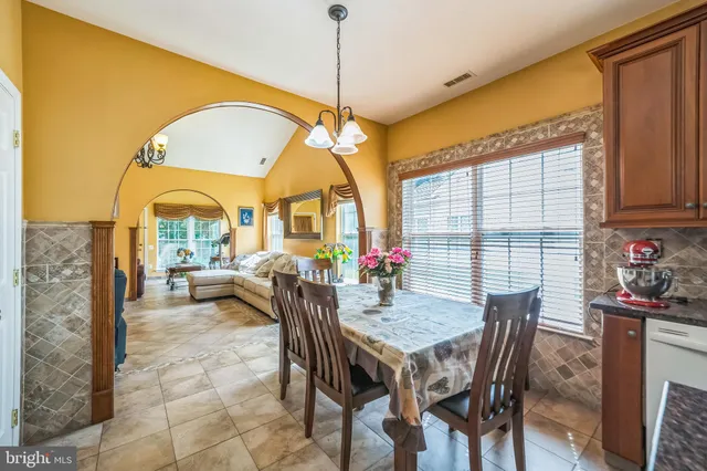 a dining room with furniture and a floor to ceiling window