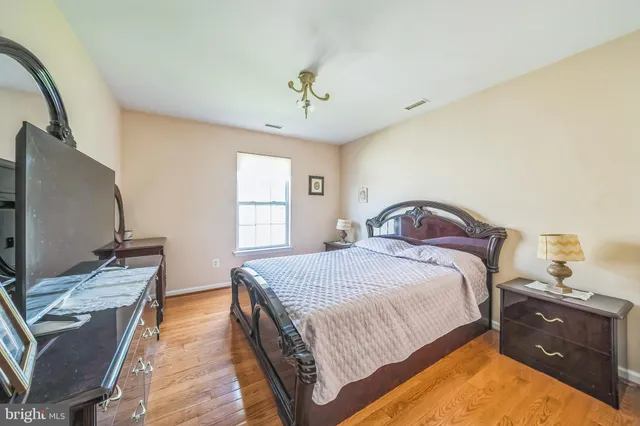 a bedroom with a bed and a flat tv screen on dresser