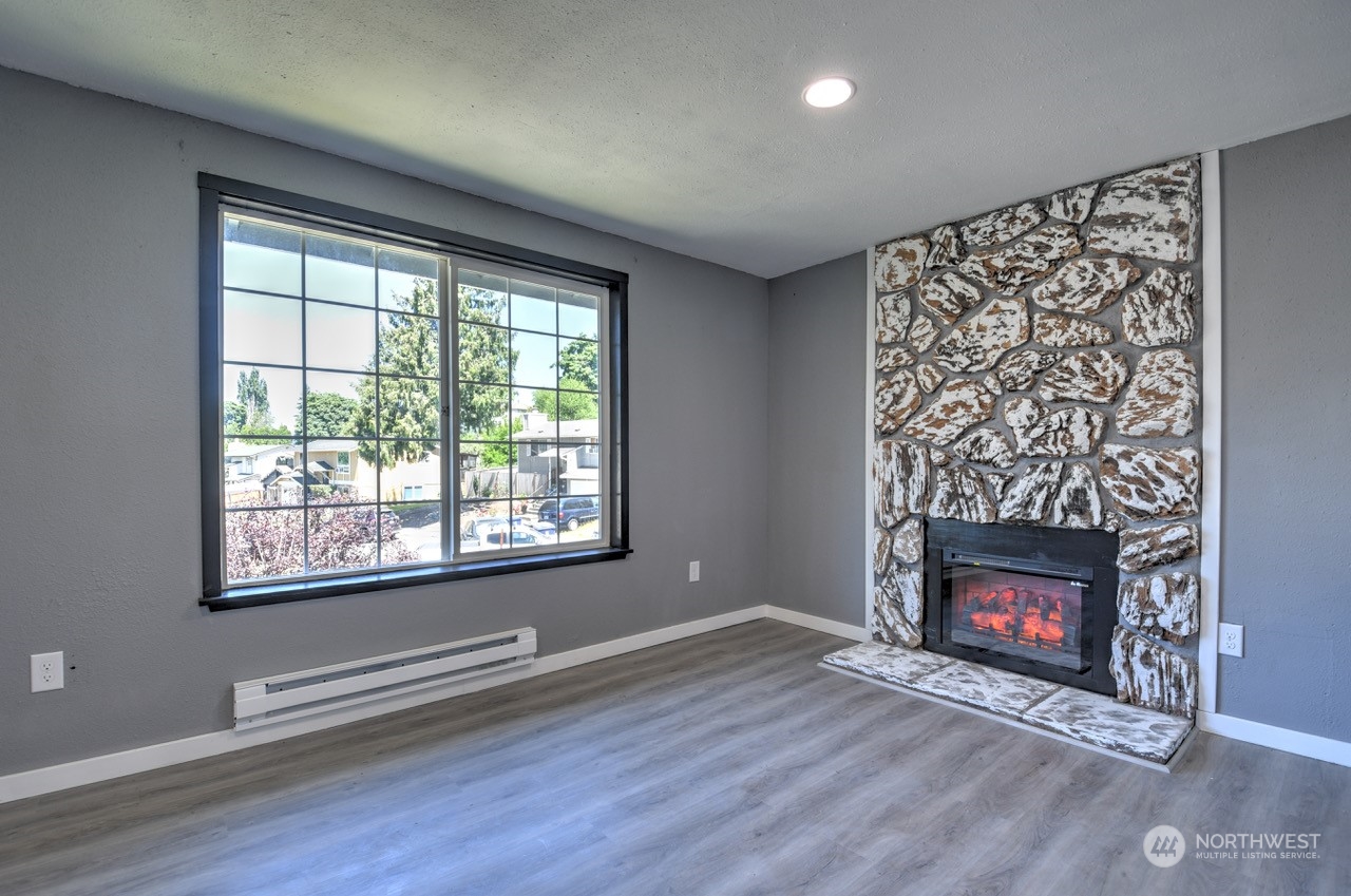 3583 East R Street Tacoma, WA 98404 - Photo 4 of 29 a view of an empty room with wooden floor fireplace and a window