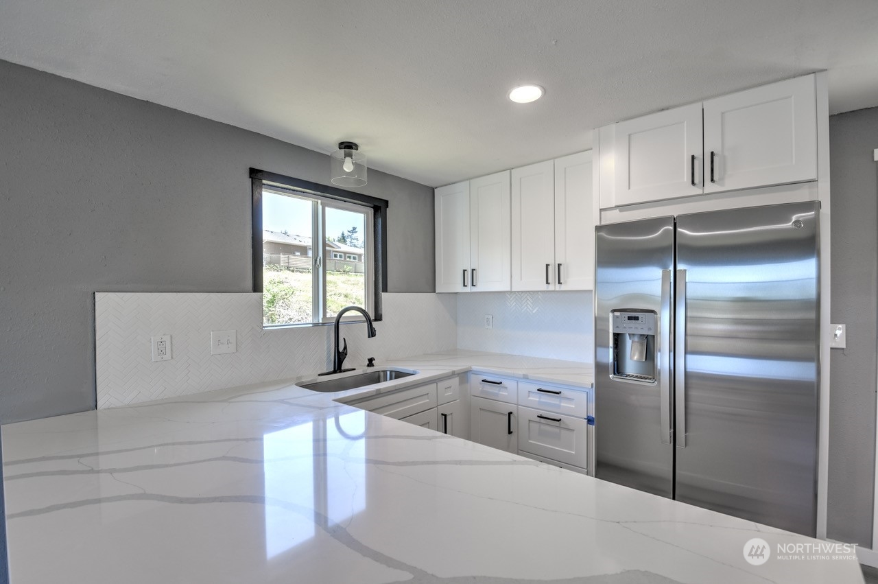 3583 East R Street Tacoma, WA 98404 - Photo 7 of 29 a kitchen with a refrigerator sink and cabinets