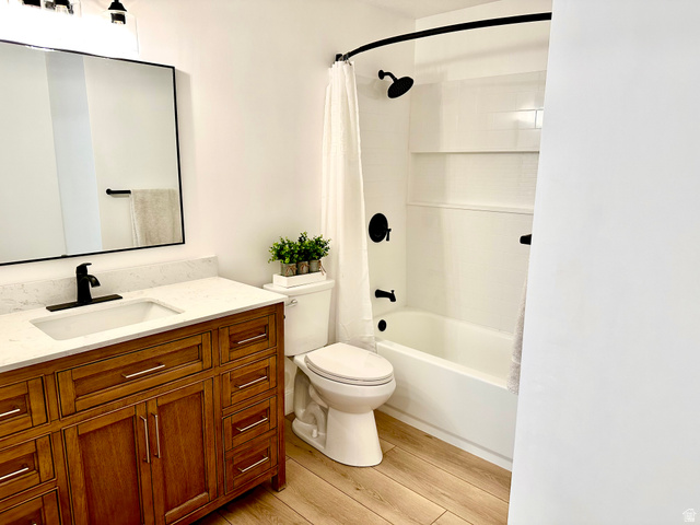 7818 North Windhover Road Eagle Mountain, UT 84005 - Photo 29 of 32 Bathroom featuring a wood-finish vanity with a light-toned countertop, integrated sink, and black hardware