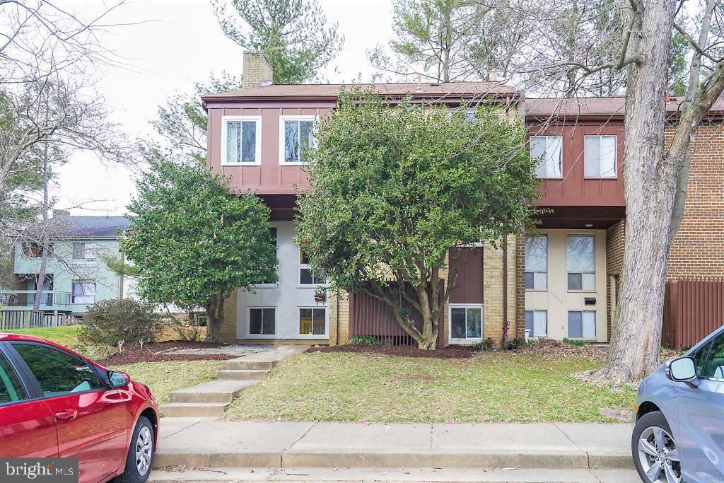 11041 Saffold Way Reston, VA 20190 - Photo 2 of 44 a front view of a house with a garden and tree