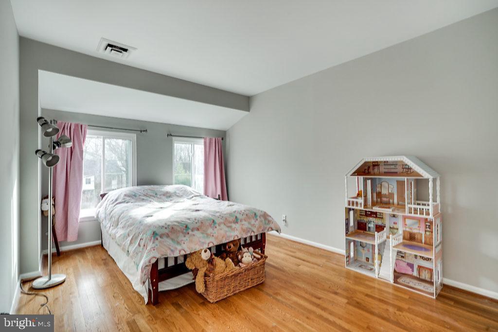 11041 Saffold Way Reston, VA 20190 - Photo 16 of 44 a bedroom with a bed and wooden floor