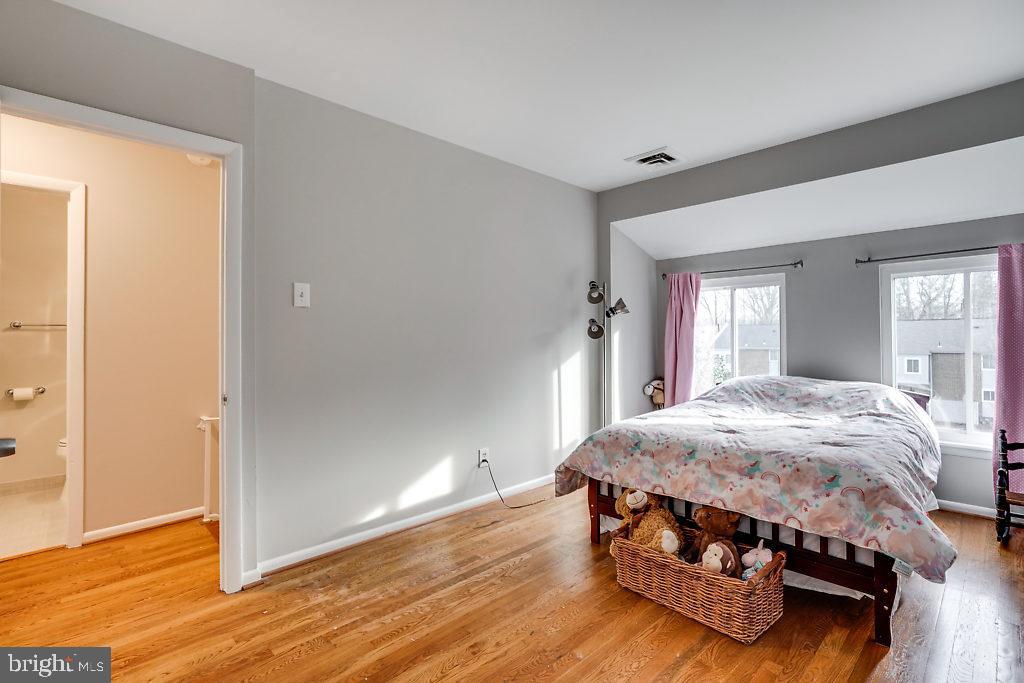 11041 Saffold Way Reston, VA 20190 - Photo 17 of 44 a bedroom with a bed and wooden floor