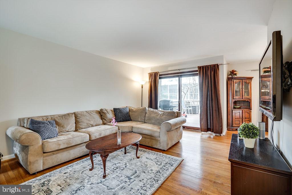 11041 Saffold Way Reston, VA 20190 - Photo 6 of 44 a living room with furniture potted plant wooden floor and a large window