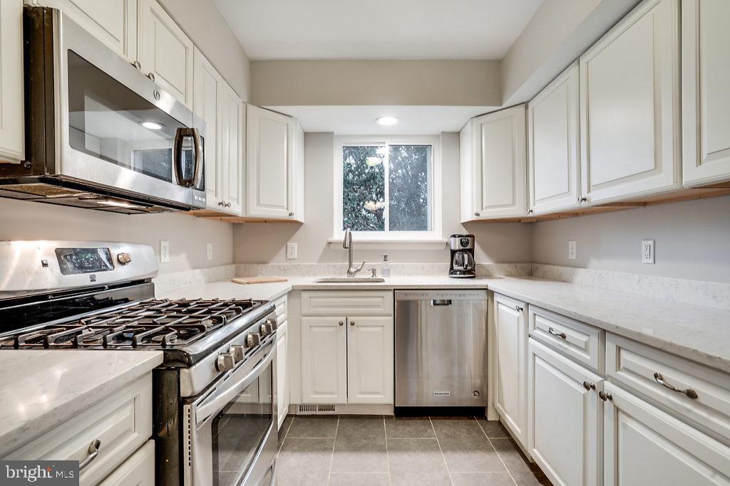 11041 Saffold Way Reston, VA 20190 - Photo 8 of 44 a kitchen with cabinets appliances a sink and a window