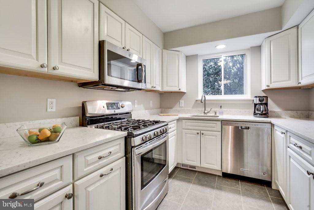 11041 Saffold Way Reston, VA 20190 - Photo 9 of 44 a kitchen with stainless steel appliances granite countertop white cabinets granite counter tops and a window