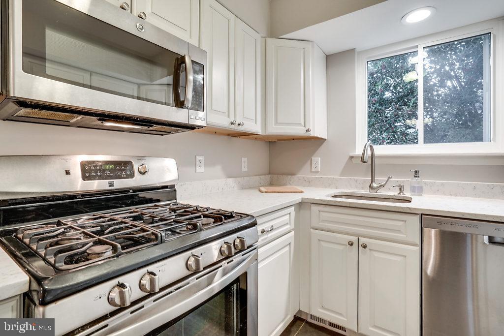 11041 Saffold Way Reston, VA 20190 - Photo 10 of 44 a kitchen with white cabinets and appliances