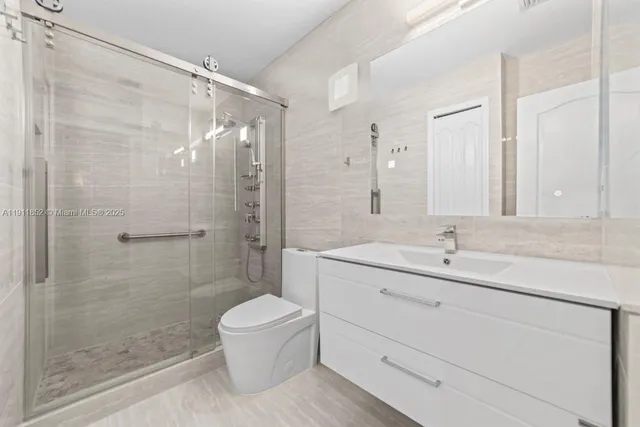 a bathroom with a shower sink vanity mirror and toilet
