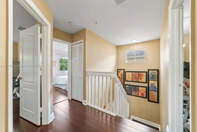 a view of a hallway with wooden floor and windows