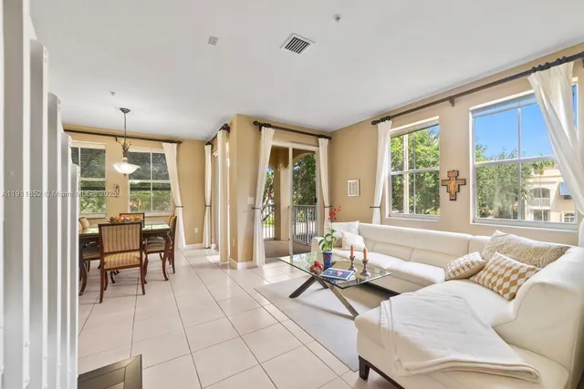 a living room with furniture and floor to ceiling windows