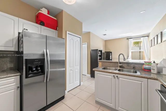 a kitchen with stainless steel appliances granite countertop a refrigerator and a sink