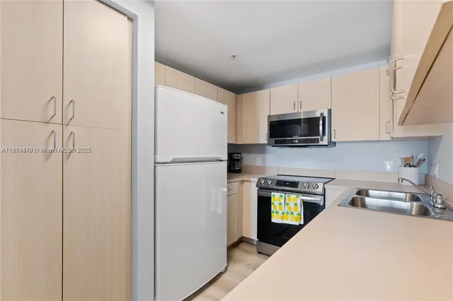 a kitchen with stainless steel appliances a refrigerator sink and microwave