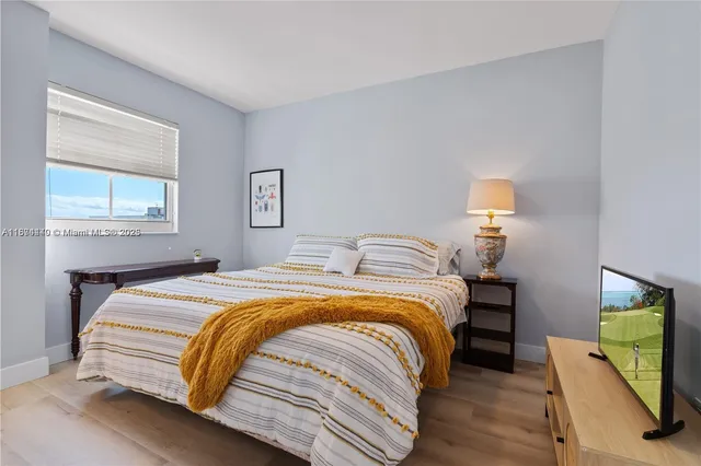 a bedroom with bed and a flat tv screen on a dresser