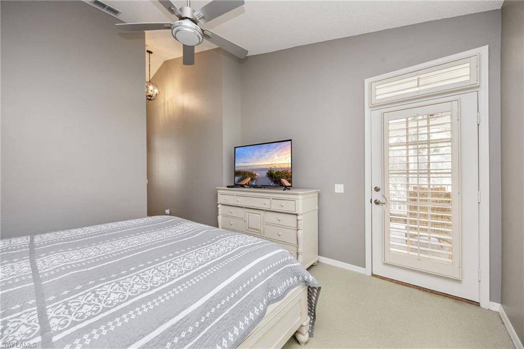 89 Silver Oaks Circle, Unit 5201 Naples, FL 34119 - Photo 14 of 21 a bedroom with a bed and a flat screen tv