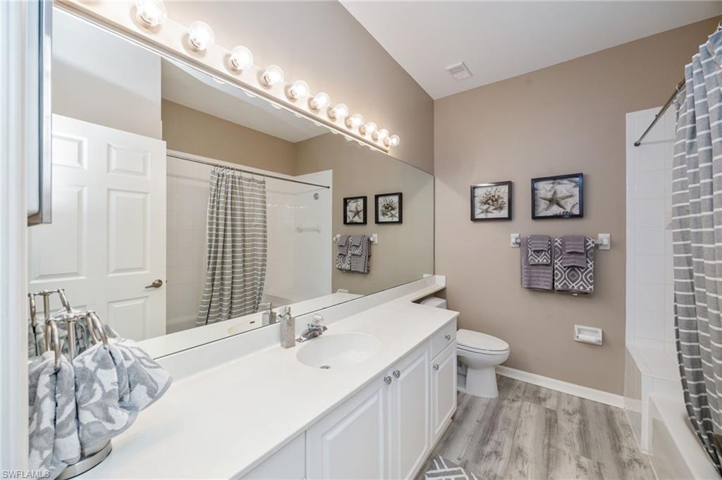89 Silver Oaks Circle, Unit 5201 Naples, FL 34119 - Photo 16 of 21 a bathroom with a double vanity sink mirror and toilet