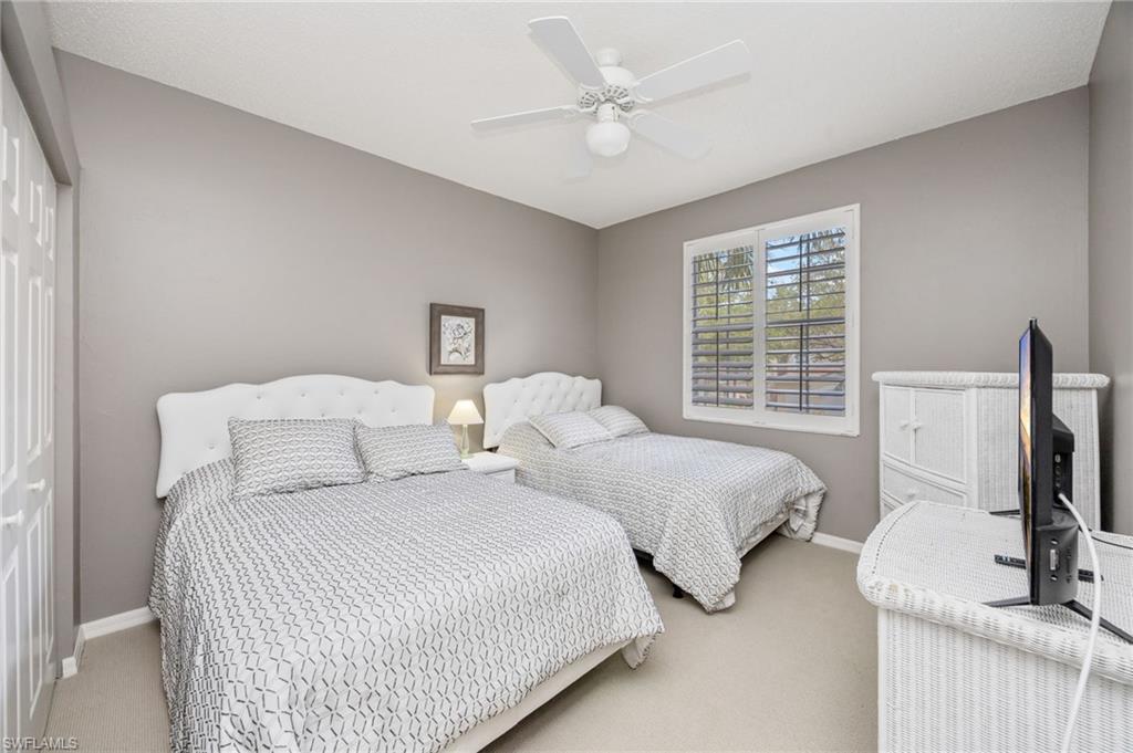 89 Silver Oaks Circle, Unit 5201 Naples, FL 34119 - Photo 17 of 21 a bedroom with two beds and a flat screen tv