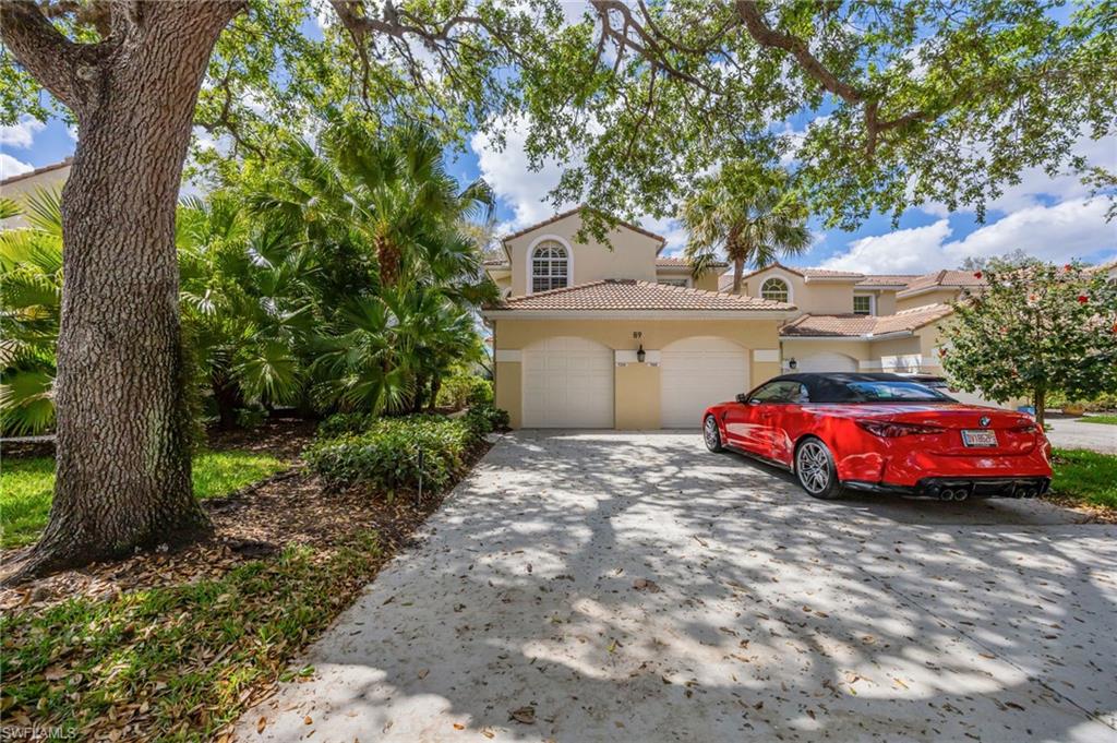 89 Silver Oaks Circle, Unit 5201 Naples, FL 34119 - Photo 2 of 21 a front view of a house with a garden