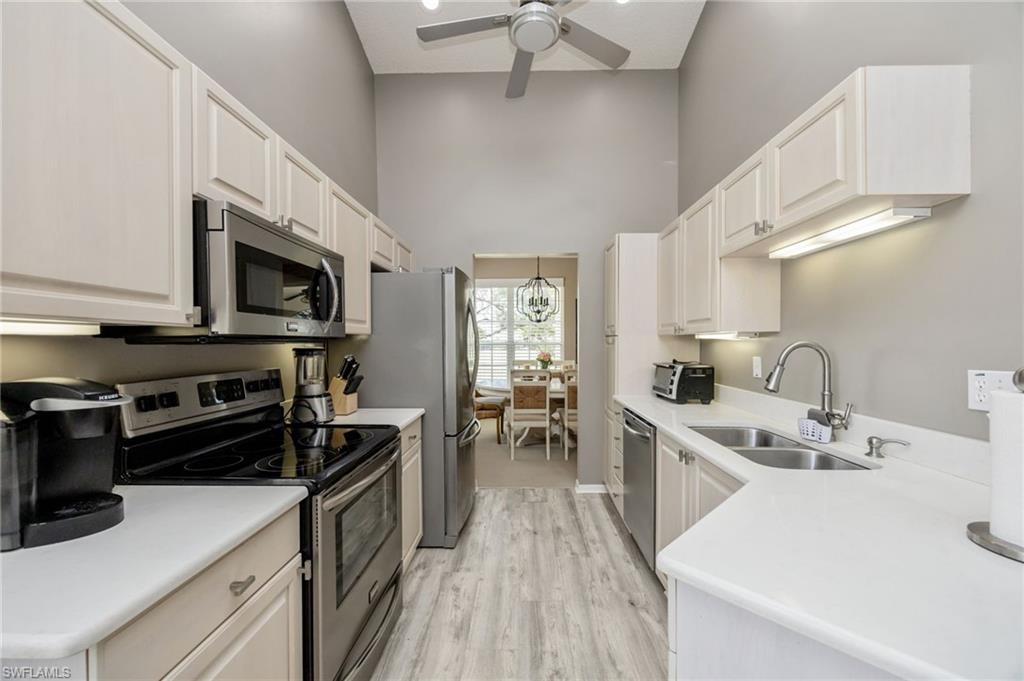 89 Silver Oaks Circle, Unit 5201 Naples, FL 34119 - Photo 5 of 21 a kitchen with stainless steel appliances a sink dishwasher stove top oven and refrigerator