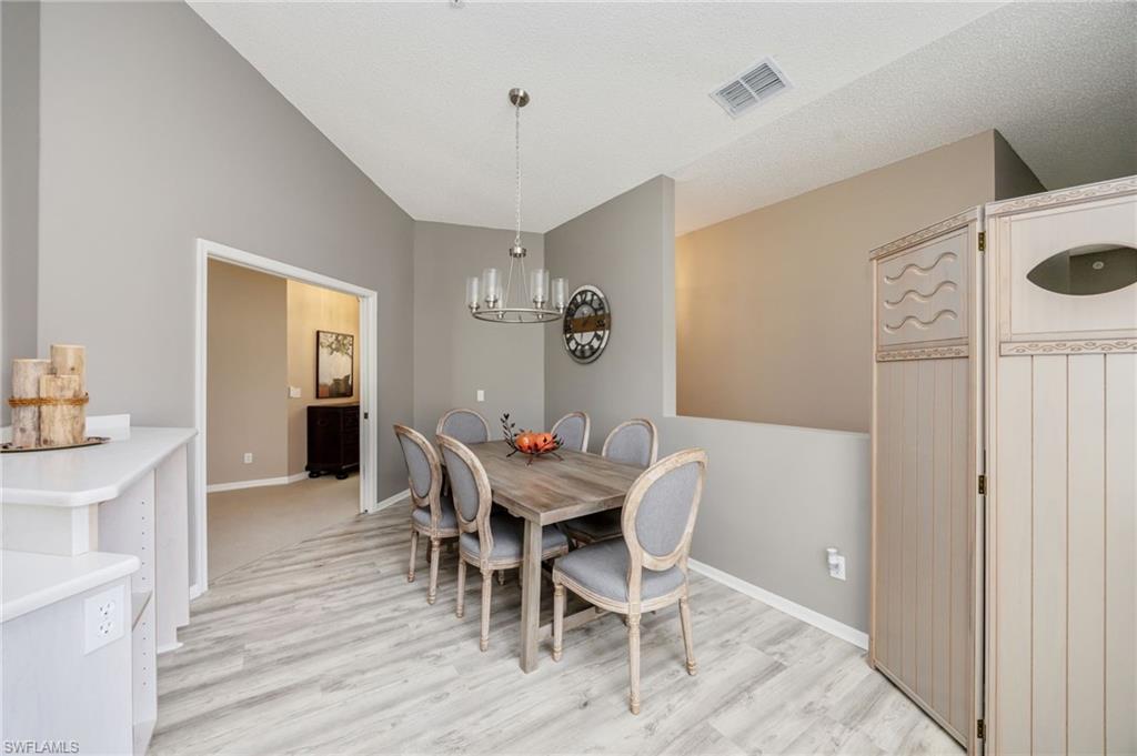 89 Silver Oaks Circle, Unit 5201 Naples, FL 34119 - Photo 6 of 21 a view of a dining room with furniture and wooden floor