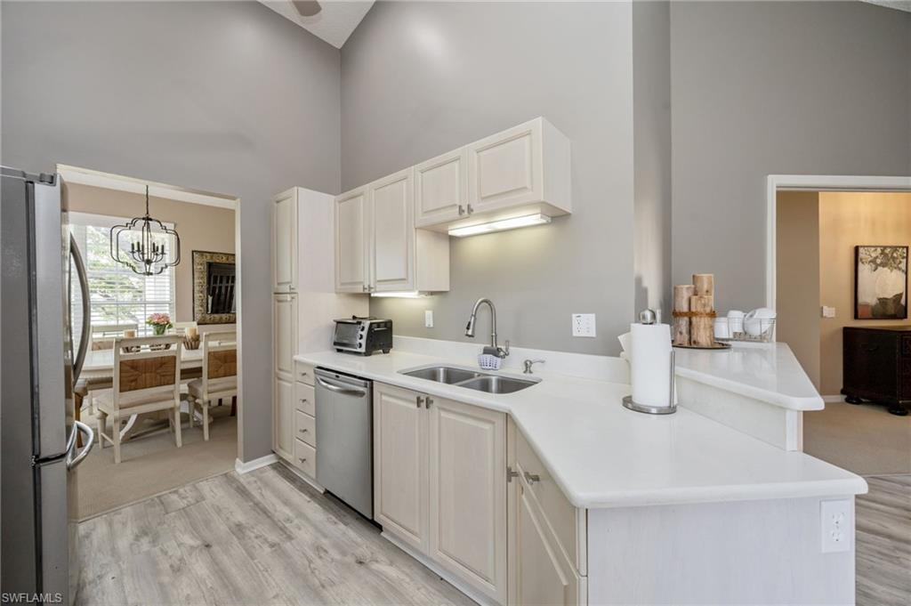 89 Silver Oaks Circle, Unit 5201 Naples, FL 34119 - Photo 7 of 21 a kitchen with a sink stove and cabinets