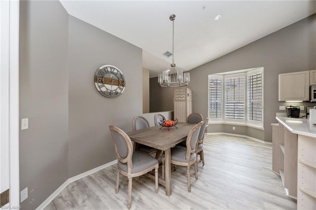89 Silver Oaks Circle, Unit 5201 Naples, FL 34119 - Photo 9 of 21 a view of a dining room with furniture window and wooden floor