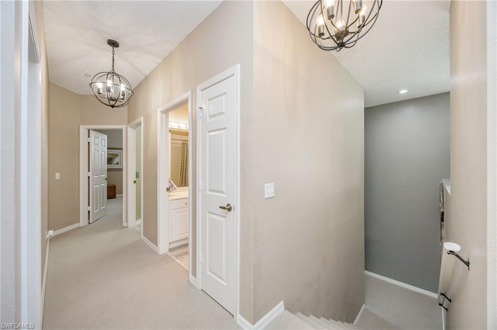 89 Silver Oaks Circle, Unit 5201 Naples, FL 34119 - Photo 10 of 21 a view of a hallway with chandelier